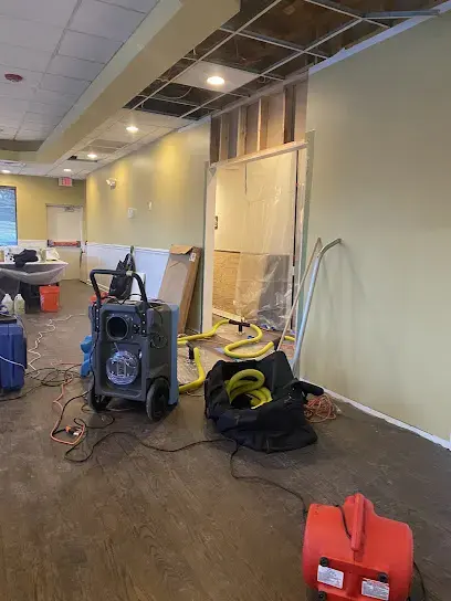 Dehumidifier and drying gear set up in a room with the lower walls cut open